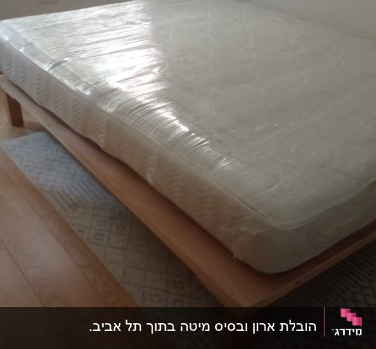 מזרן עטוף בניילון על מיטה מעץ בחדר שינה